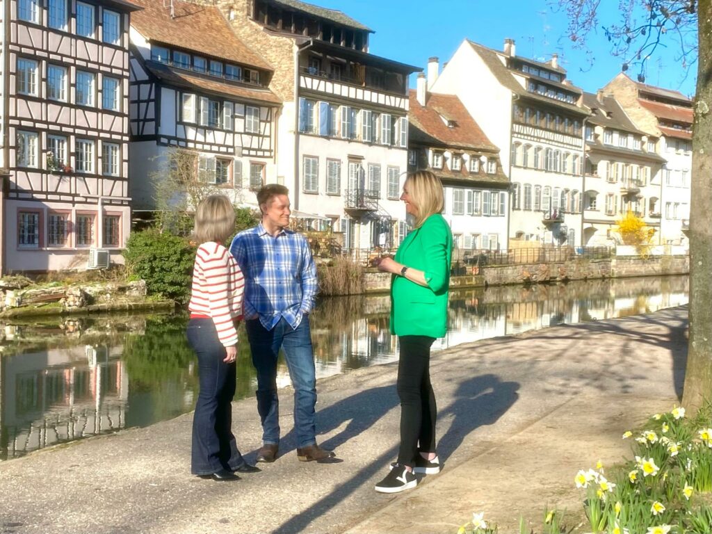Eleanor Moore and a couple, talking near a canal in Strasbourg